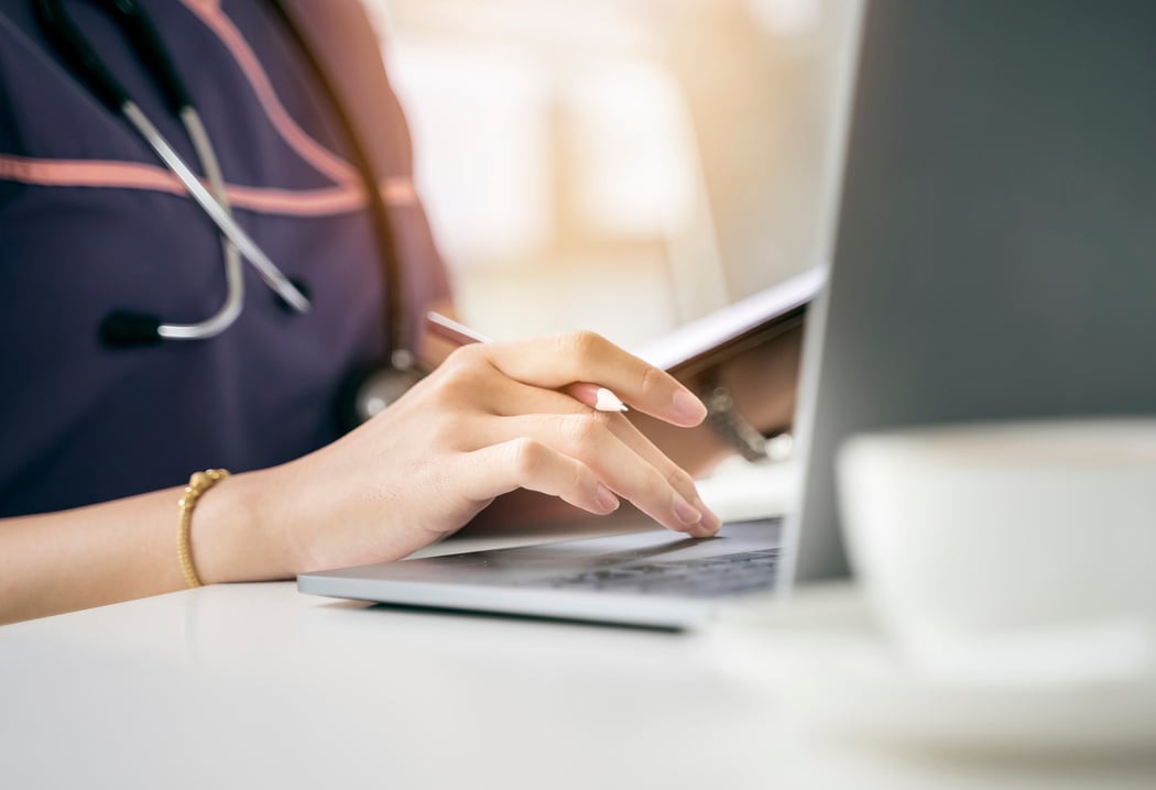 Close up short nurse hand using laptop